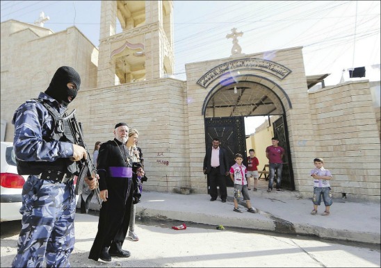 A militant Islamist stands guard over a captured Christian church in Iraq.
